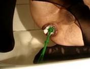 Трансвестит в женских капроновых колготках, сидит в пустой ванной и впихивает в своё дристалище колючего ерша